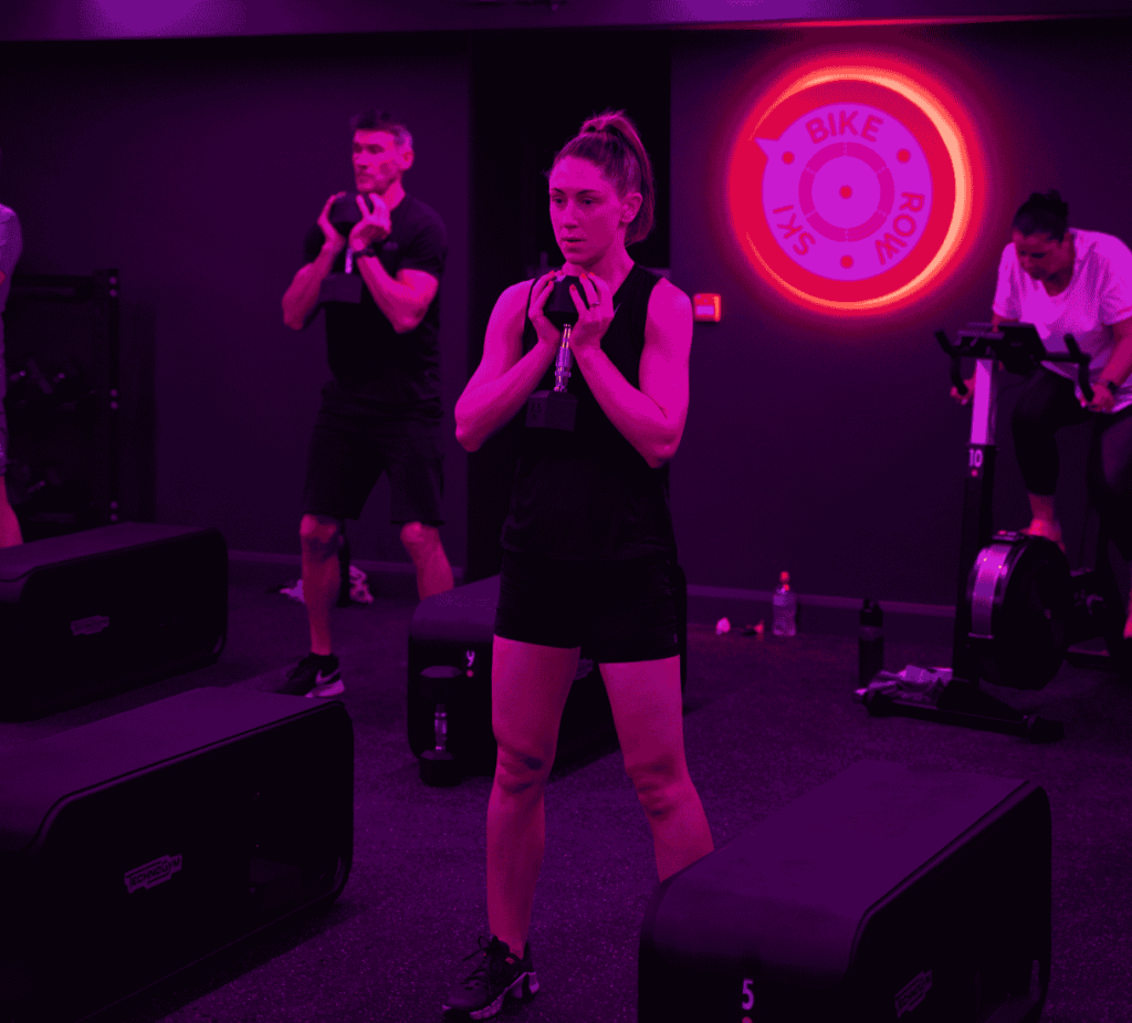 Supportive coaching at BikeRowSki helping a member feel confident in class